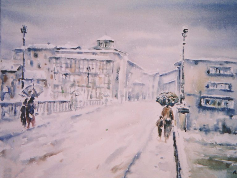 Puente cubierto de nieve con edificios al fondo y personas caminando.